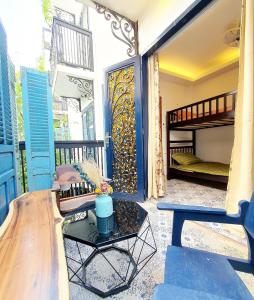 胡志明市The Lovenote Home的客房设有带一张床和一张桌子的阳台。
