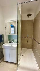 伦敦Sienna's 2 - bedroom apartment, London, N1.的一间带玻璃淋浴和水槽的浴室