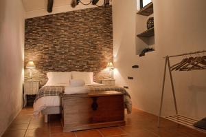 阿兰德鲁阿尔Monte Alecrim的一间卧室设有一张床和砖墙