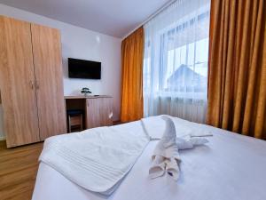 摩尔多维察Vila Victoria Moldovița的一间卧室配有一张带白色床单的床和一扇窗户。