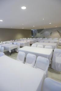 切图马尔TRYP by Wyndham Chetumal的一间设有白色桌子和白色椅子的房间
