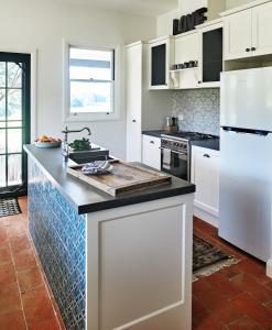 GlenifferThamarra Cottage的厨房配有白色橱柜和台面