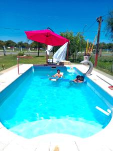 特尔马斯德里奥翁多LA CABAÑA的2人使用带遮阳伞的游泳池