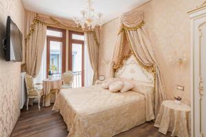威尼斯Canal View San Marco Luxury Rooms的一间卧室配有一张床和一个吊灯