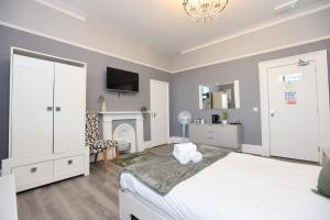 利物浦Hotel Anfield的卧室配有白色的床和壁炉