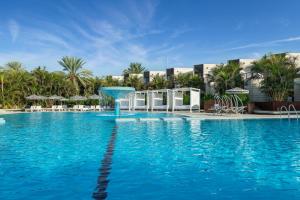 埃拉特Riviera by Isrotel Collection的一座拥有蓝色海水和棕榈树的游泳池