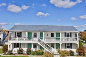 五月岬郡南风汽车旅馆的一座带绿色百叶窗的大型白色房屋