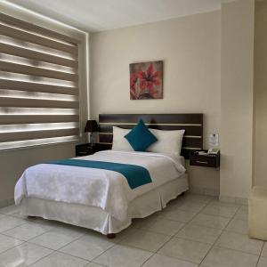 波托维耶霍Hotel Ceibo Dorado的一间卧室配有一张带蓝白色枕头的大床