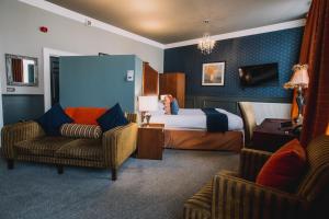 兰卡斯特太阳酒店&酒吧的酒店客房,配有一张床和两把椅子
