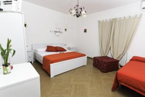 Villaggio RestaDolce Salento的一间卧室配有带橙色床单和椅子的床