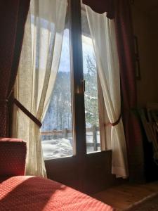 博格塔塞斯特雷Cozy mountains apartments的一间卧室设有窗户,享有积雪覆盖的庭院的景色