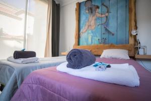马希库Modern & Recycled Guest House的两张床,带毛巾,上面有一只动物填充