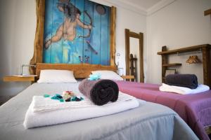 马希库Modern & Recycled Guest House的一间卧室配有两张带毛巾和绘画的床