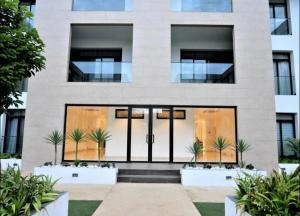 阿克拉Splendid Apartments - Embassy Gardens的前面有玻璃门和植物的房子