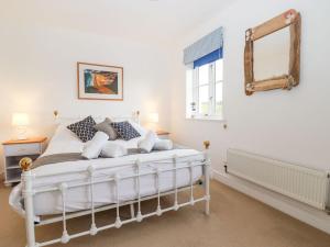 特鲁罗Meadow View的卧室配有白色的床和镜子