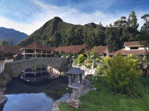 乌鲁班巴阿让洼圣谷疗养酒店的一座桥,在池塘上,在山底下