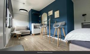 赖因斯贝格Sommerhäuschen的一间卧室设有蓝色的墙壁、一张床和凳子。
