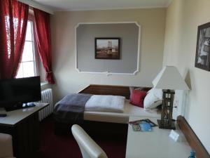 德伯尔恩维贝塔贝酒店的一间卧室配有一张床和一张书桌及电视