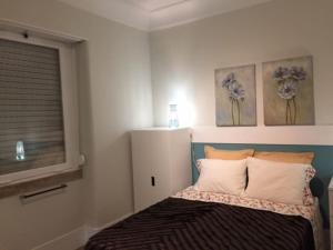 里斯本Romantic and Bright Studio Apartment in Arroios - SSL 2B的卧室配有一张壁画和两张画的床铺。