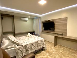 皮拉尼亚斯O Canto Pousada的一间卧室配有一张床和一台平面电视