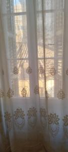 科孚镇''Dei Vecchi'' apartment in Kerkyra的窗户有白色窗帘,阳光照耀着