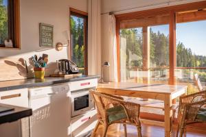 基洛纳Myra Canyon Lodge的一个带桌椅和大窗户的厨房