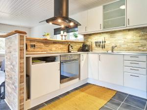 维斯特索马肯4 person holiday home in Aakirkeby的厨房配有白色橱柜和炉灶。