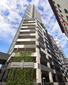 蕉赖Eshue Designer Suites @ Simfoni Towers的一座高大的建筑,旁边是植物