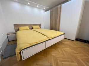 VisokoMici's Apartments的一间卧室配有一张带黄色毯子的大床