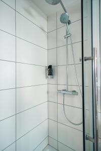 米赫拉克尔施费斯艾克酒店的浴室铺有白色瓷砖,设有淋浴。