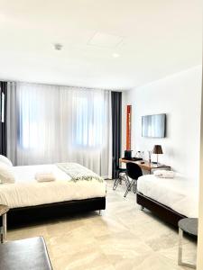 贝加莫Le Muraine的酒店客房配有两张床和一张书桌