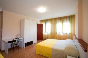 托莱港Hotel Ristorante Klaus的一间卧室配有一张床、一张书桌和一个窗户。