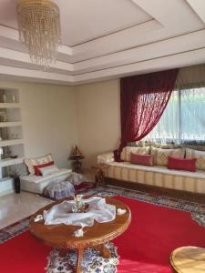 马拉喀什Marrakech le joyau Big villa piscine privée jardin的客厅配有沙发和桌子