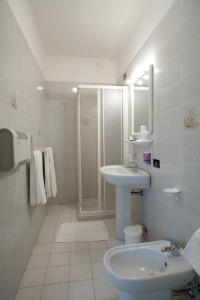 托莱港Hotel Ristorante Klaus的白色的浴室设有水槽和淋浴。