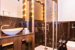谢尔丁Loft Suite im modernen Style in Schärding的一间带水槽和玻璃淋浴的浴室