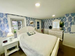 大洋城大西洋之家住宿加早餐旅馆的卧室配有白色的床和蓝色及白色的壁纸