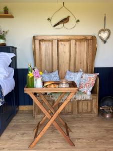 兰波特Marsh Farm Glamping Shepherd Hut的一张木桌,位于带一张床的房间里