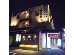 IchiharaBusiness Hotel Goi Onsen - Vacation STAY 78238v的一座建筑物,晚上在建筑物的一侧有标志