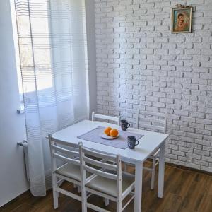 PodgorodtsyСадиба Лісова的一张带两把椅子的白色桌子和橙子