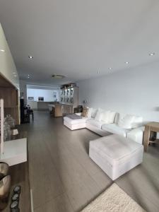 洛斯克里斯蒂亚诺斯Nosotros Luxury Villa的一间带白色沙发的客厅和一间厨房