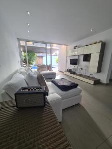 洛斯克里斯蒂亚诺斯Nosotros Luxury Villa的一间带白色沙发的客厅和一间厨房