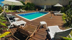 埃斯特角城米兰酒店的一个带椅子的木制甲板和游泳池