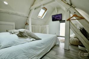 Le VaudreuilChez Marcel的卧室配有白色的床和窗户。