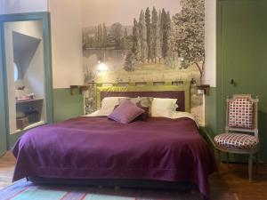 阿瓦隆B&B Vassy Etaule的一间卧室配有一张带紫色毯子和椅子的床