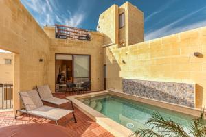 Tal-BarmilNarcisa - Luxury 3BR Traditional House with Pool, Cinema & Hot Tub的一座带游泳池和两把椅子的房子
