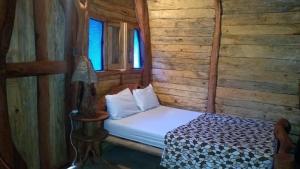 圣希尔EL RODEO的木墙客房内的小床