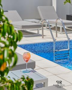 罗萨里奥广场里尔套房酒店的坐在游泳池旁的桌子上喝一杯