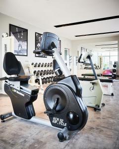 罗萨里奥广场里尔套房酒店的一间设有跑步机和举重器材的健身房的客房