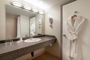 圣约翰堡Ramada by Wyndham Northern Grand Hotel & Conference Centre的一间带水槽和镜子的浴室