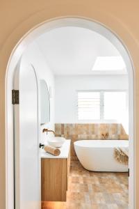 巴利纳Entre Palmas Ballina的浴室配有白色浴缸和水槽